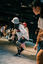 woman in white shirt and black shorts running on track field