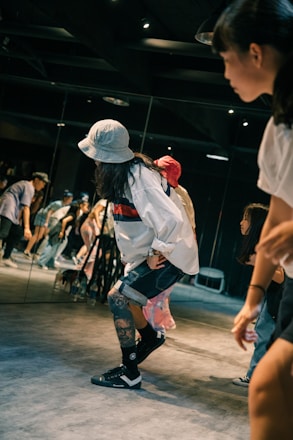 woman in white shirt and black shorts running on track field