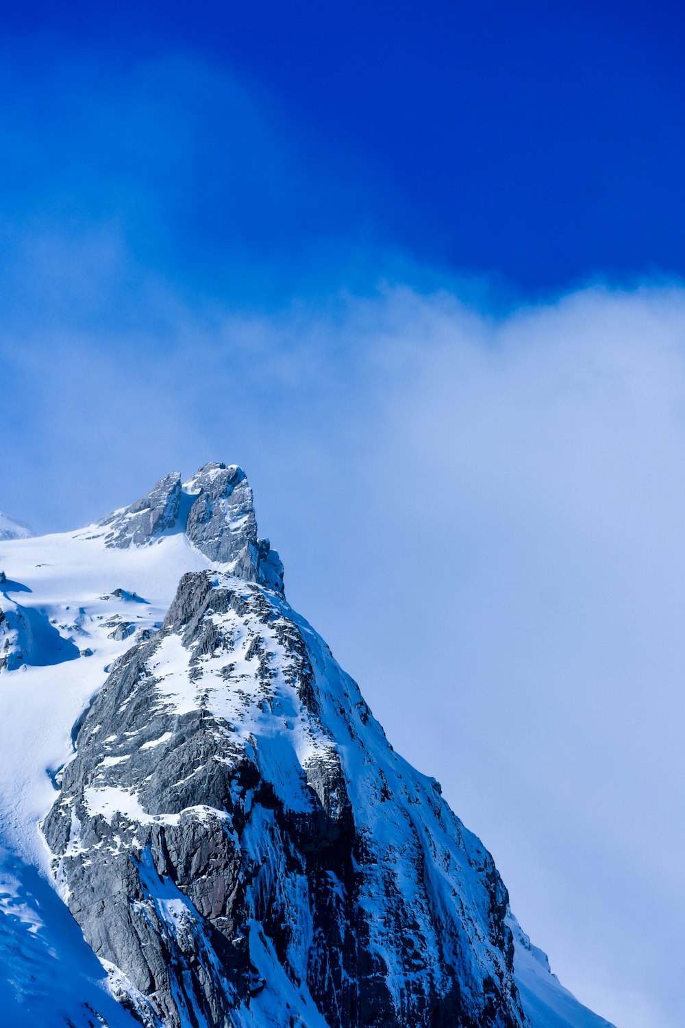 Schneebedeckter Berg unter blauem Himmel tagsüber