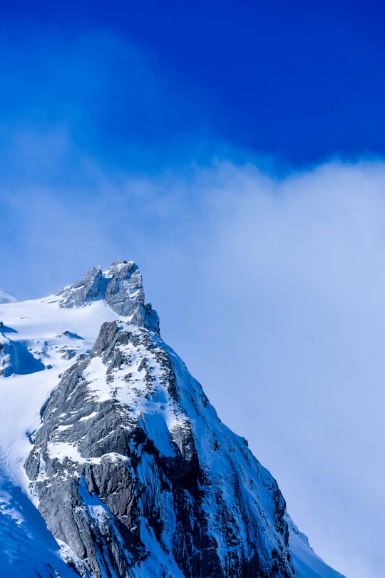 snow covered mountain under blue sky during daytime in Franz Josef Glacier New Zealand