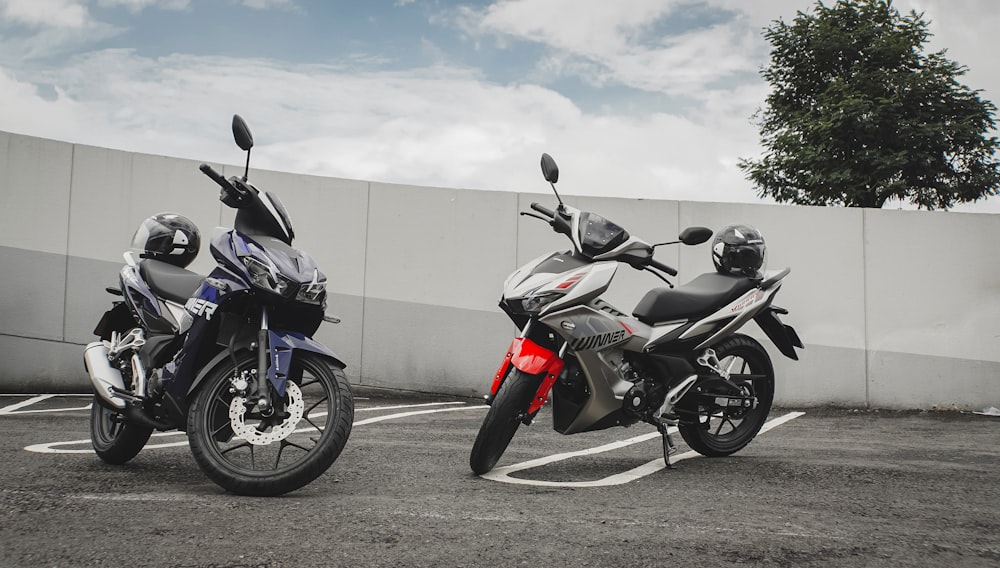 black and red sports bike parked beside beige wall