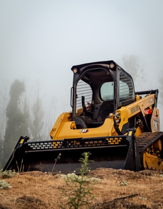 yellow and black heavy equipment on brown grass field