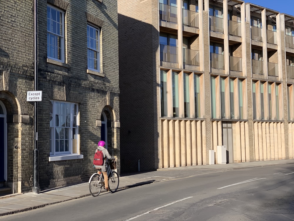 man in red jacket riding bicycle on road during daytime