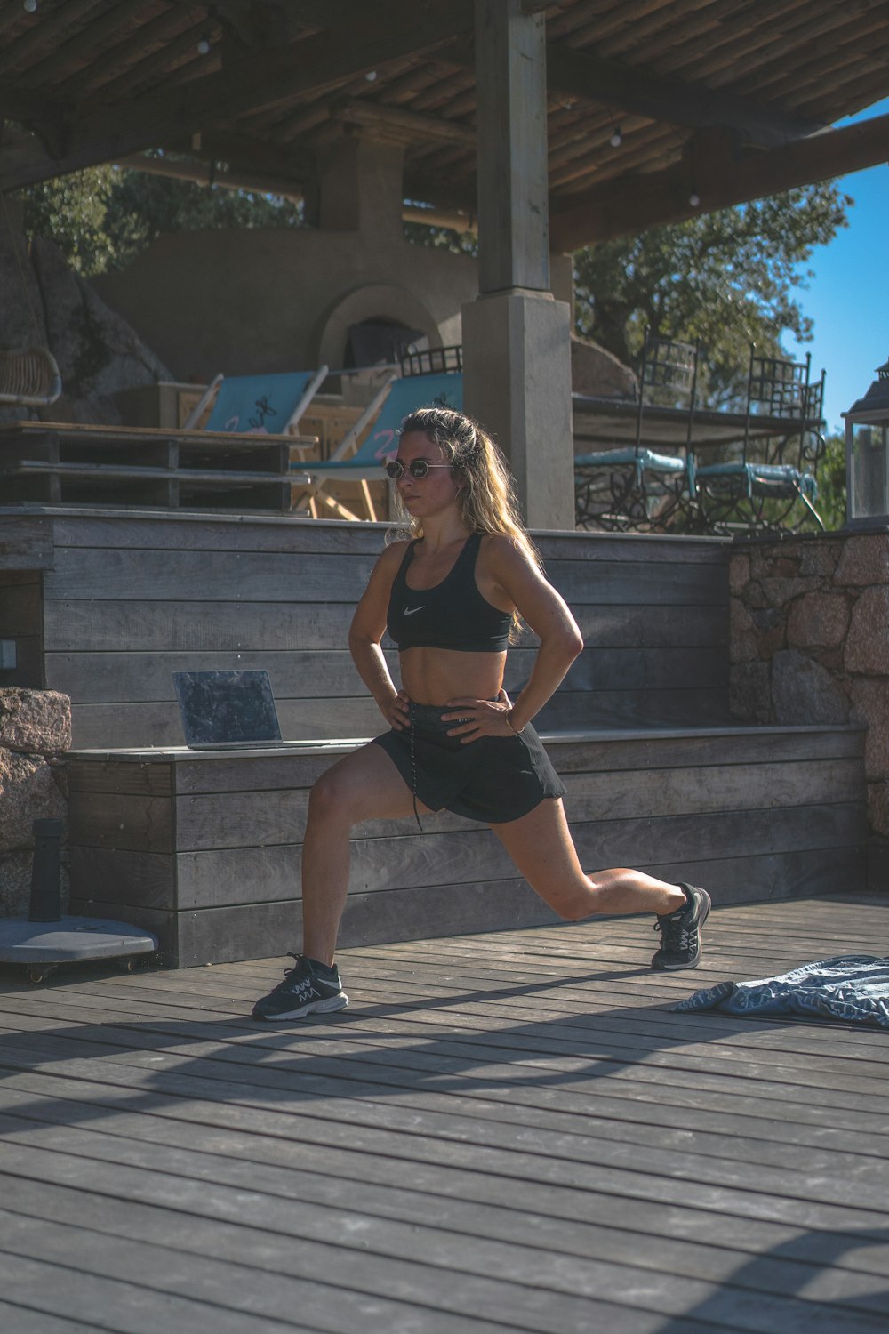 Woman in black sports bra and black shorts sitting on concrete