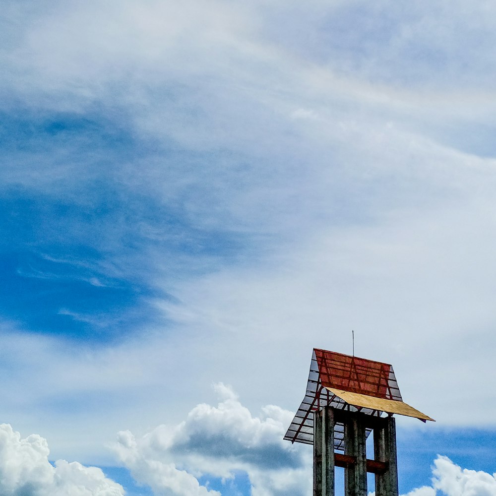 Braunes Holzhaus unter blauem Himmel und weißen Wolken tagsüber