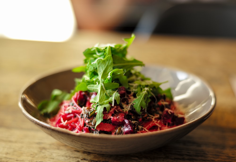 Ensalada de verduras en bol de cerámica marrón