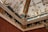 An intricately decorated ceiling corner with ornate moldings and paintings. The design includes classical motifs, floral patterns, and detailed frescoes depicting figures. Rich colors and gilded elements enhance the luxurious and artistic appeal.