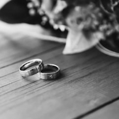 silver wedding band on wooden table