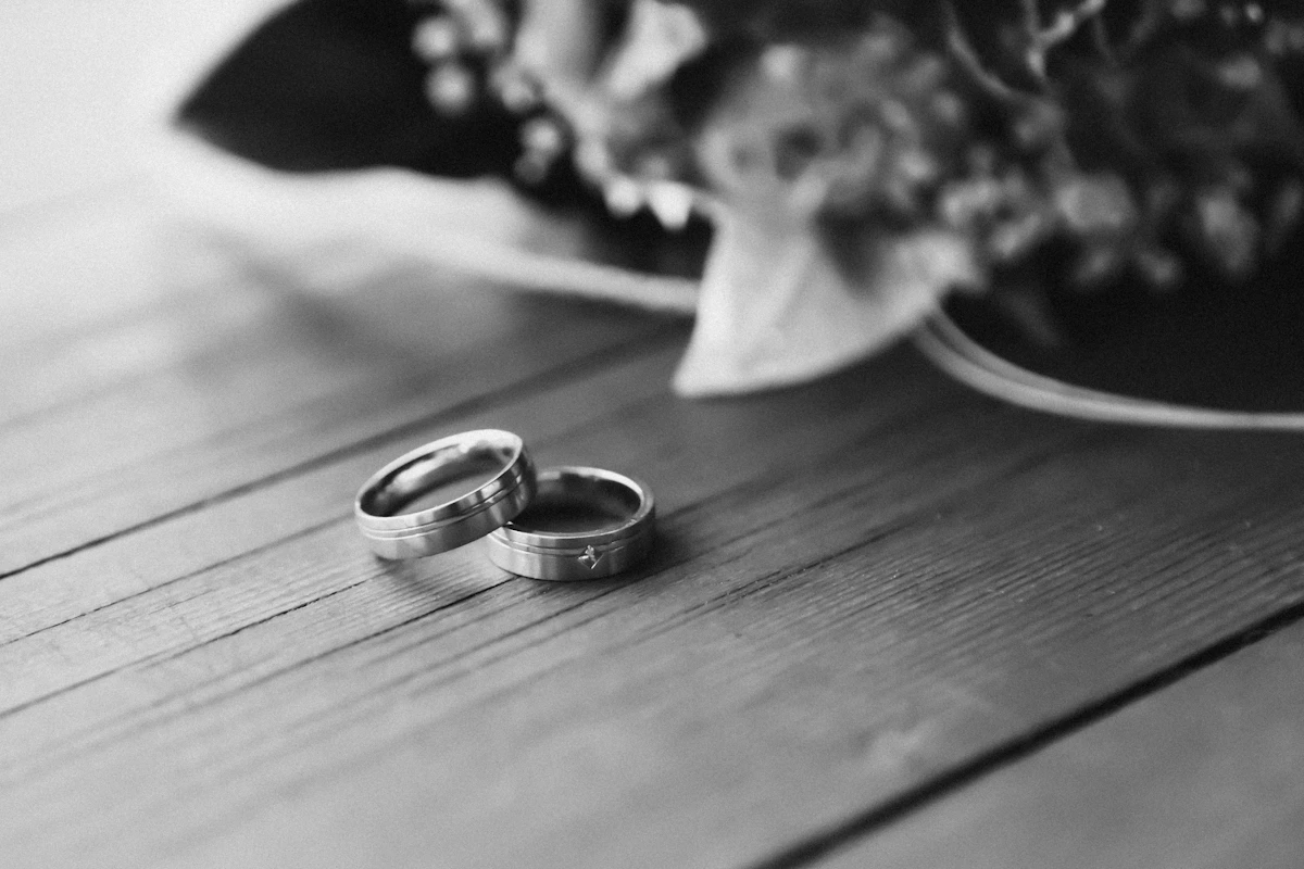 Cincin kawin perak tergeletak sendirian di atas meja kayu