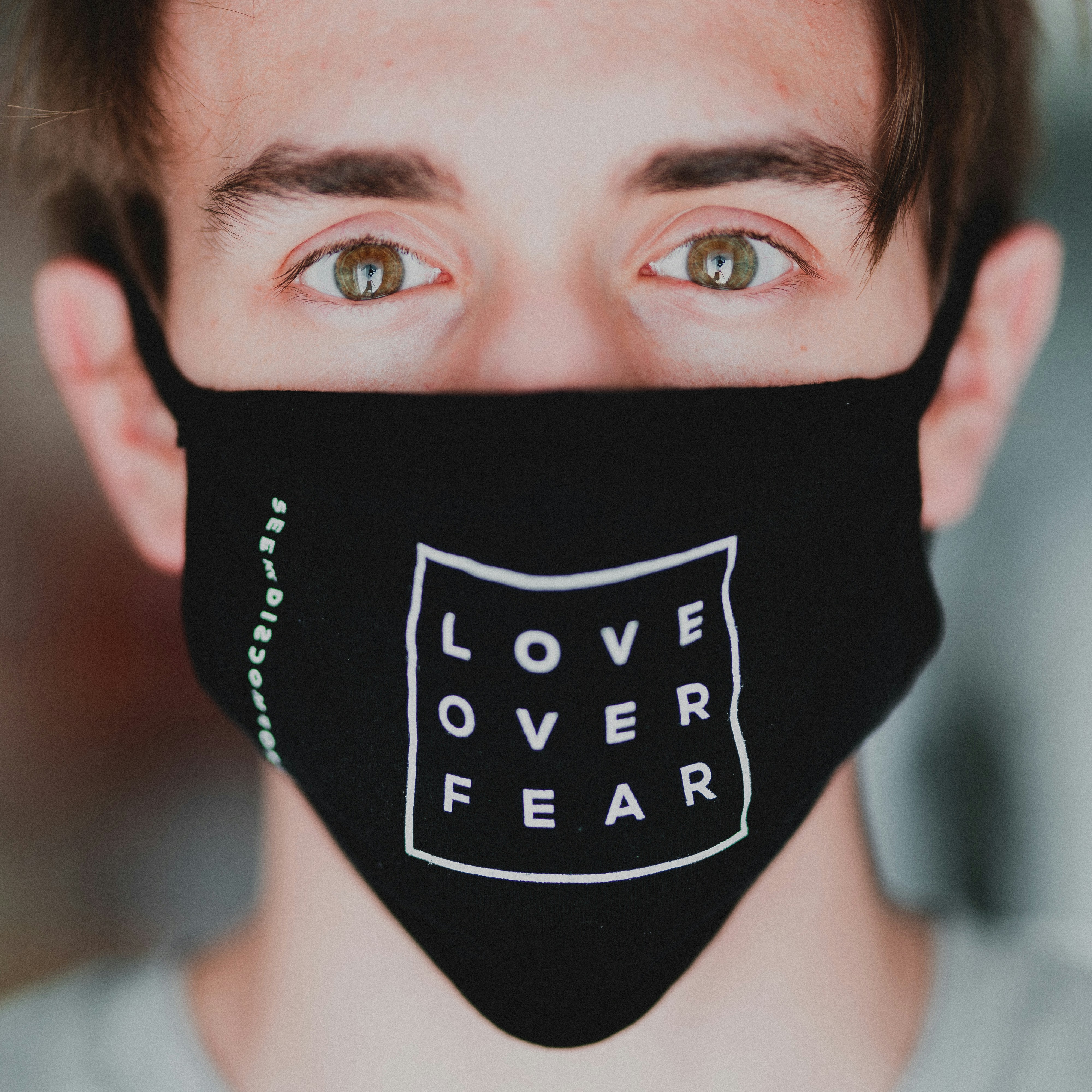 white male wearing a mask that says Love Over Fear