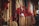 A collection of colorful beaded necklaces with tassels is displayed, with beads of various sizes and colors such as beige, brown, and deep red. The necklaces are hanging closely together, creating a dense and vibrant texture.