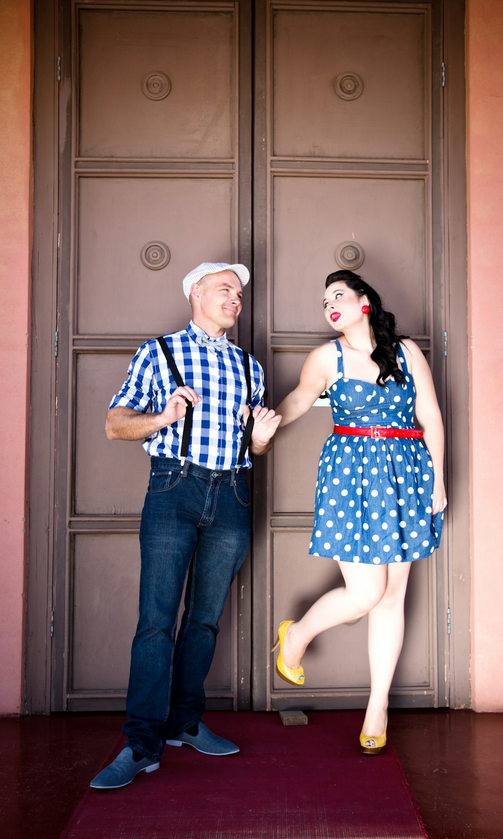 man and woman standing beside brown wooden door