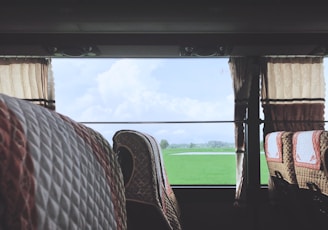 Comfortable bus seats with passengers relaxing during a countryside trip.