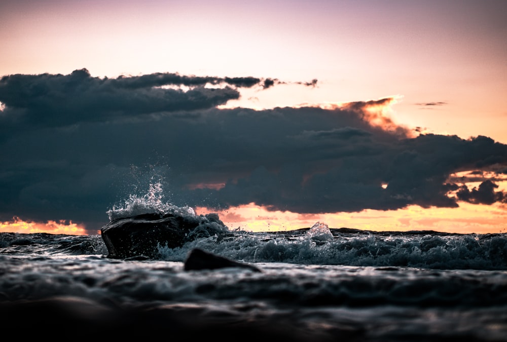 ocean waves crashing on rocks during sunset