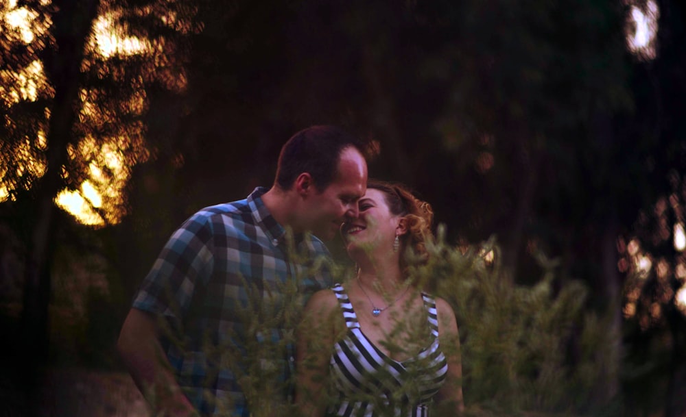 man in blue and green plaid button up shirt kissing woman in black and white stripe