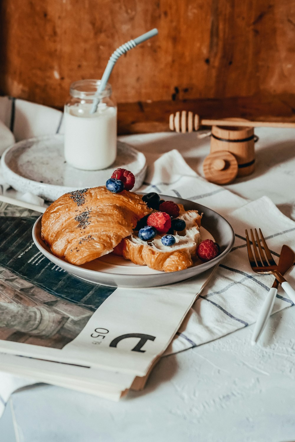 pain sur plaque en céramique blanche à côté d’une fourchette et d’un couteau en acier inoxydable