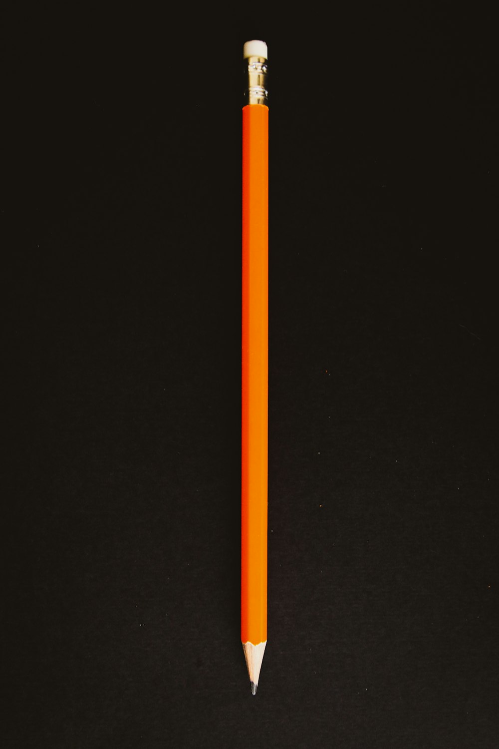lápis laranja no têxtil preto