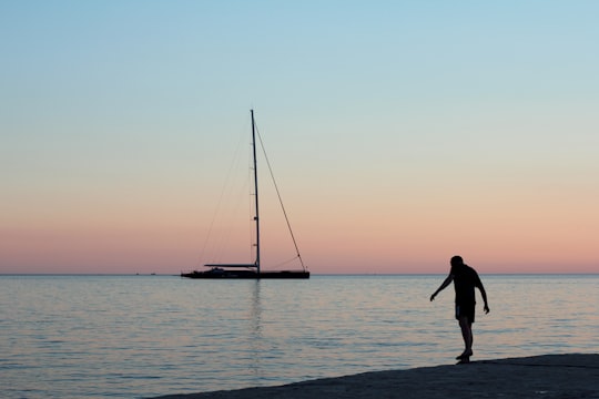 silhouette of person standing on sea shore during sunset in Rovinj Croatia