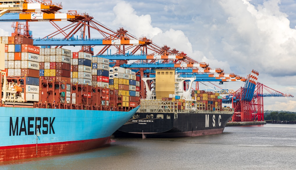 blue and red cargo ship on dock during daytime