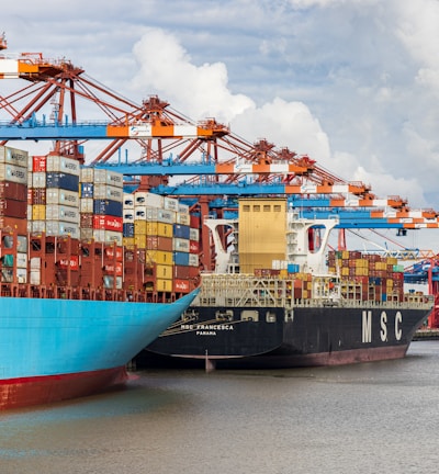 blue and red cargo ship on dock during daytime