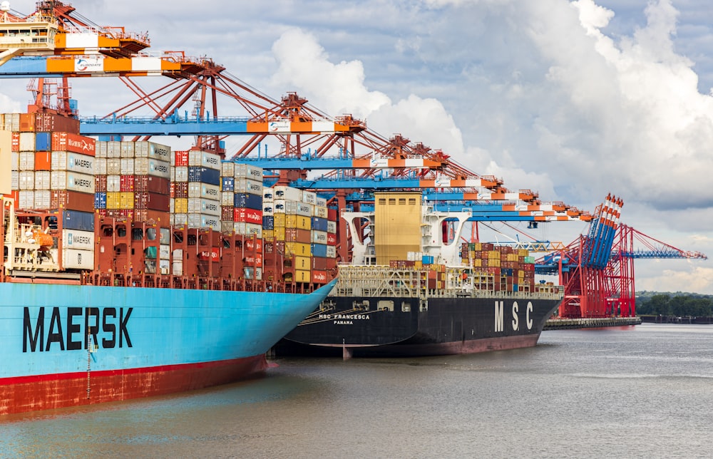 blue and red cargo ship on dock during daytime