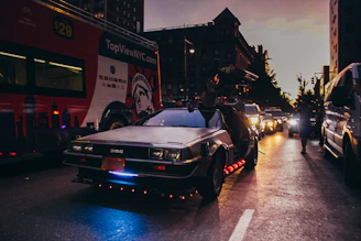 A vibrant photo of a live concert tour bus with the Delorean Prod logo, set against a city skyline at dusk.
