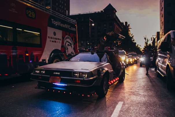 A vibrant photo of a live concert tour bus with the Delorean Prod logo, set against a city skyline at dusk.