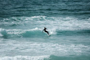 man surfing on sea waves during daytime