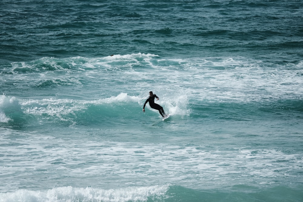 昼間、海の波でサーフィンをする男