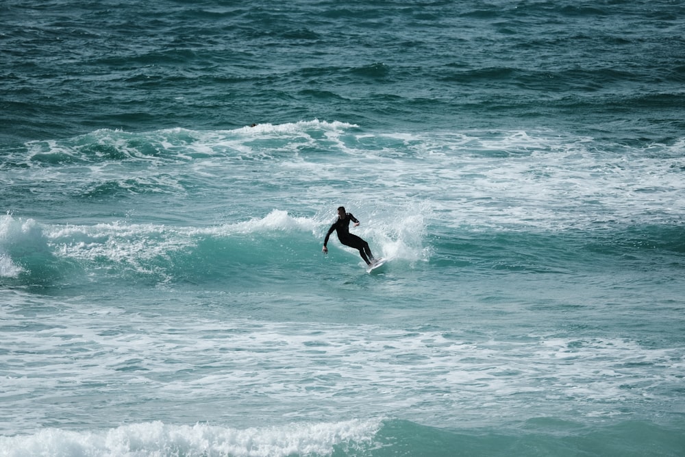 man surfing on sea waves during daytime