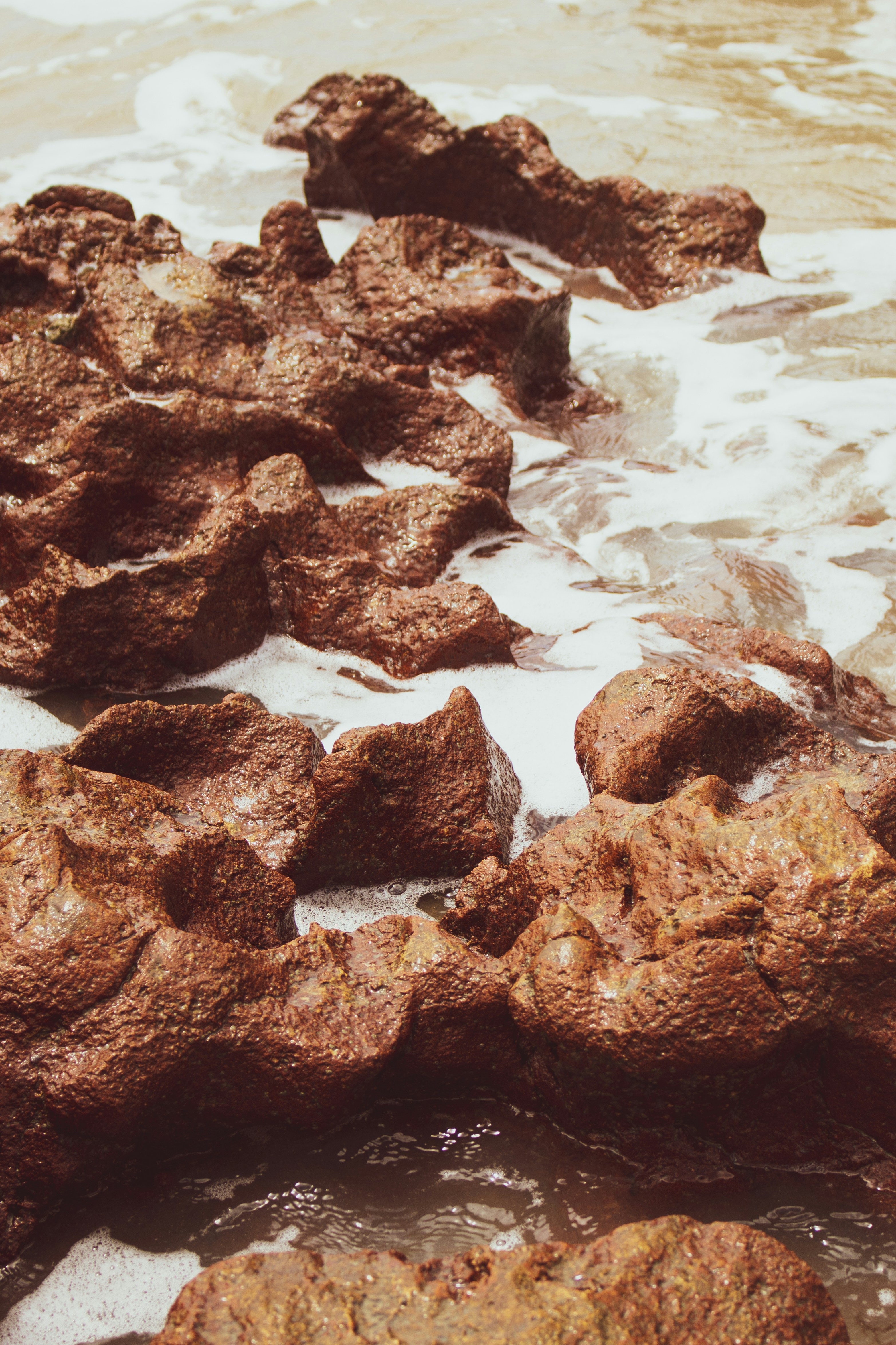 brown rock formation on body of water during daytime
