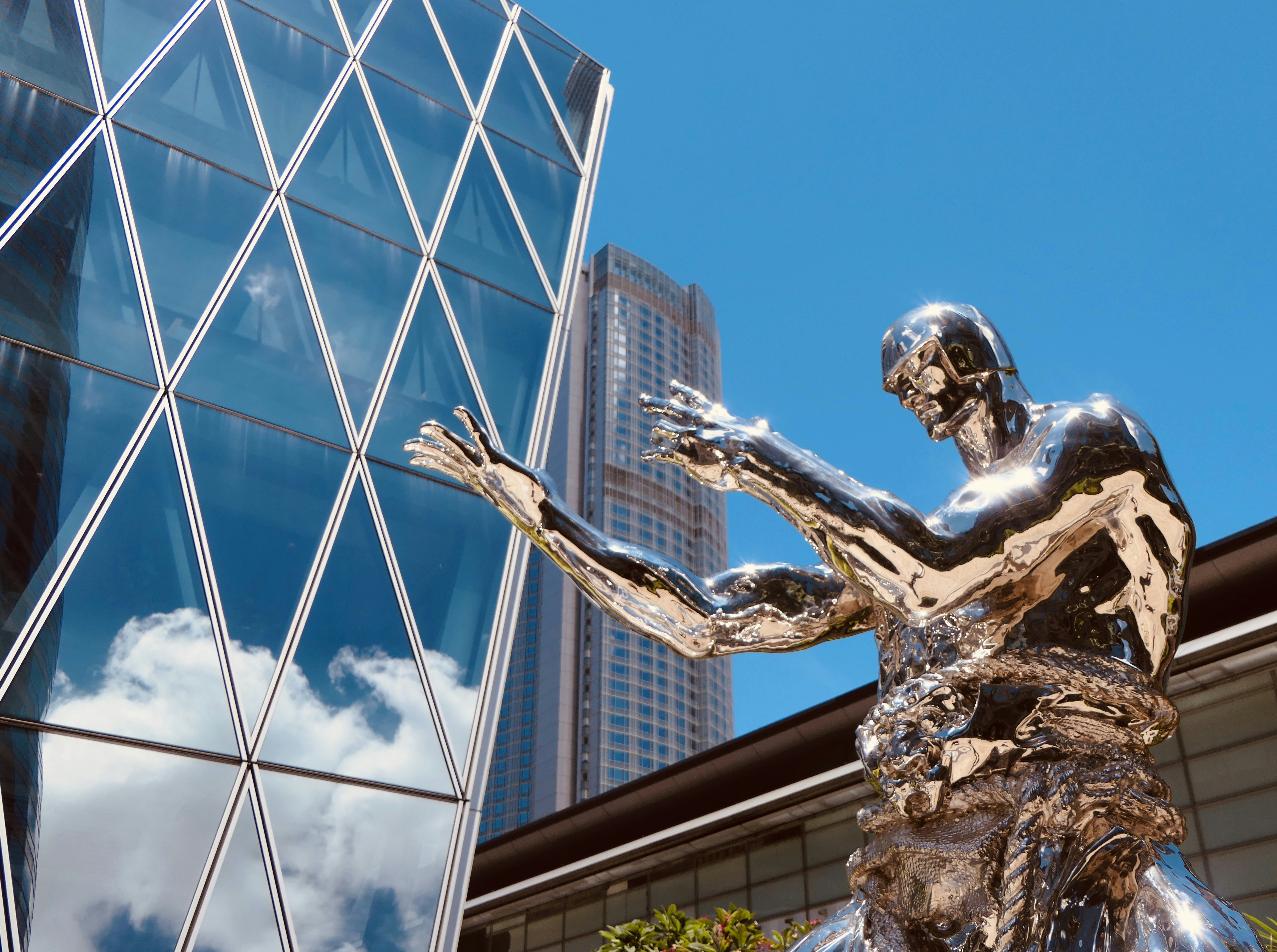 Man with wings statue near glass building during daytime photo Free Exchange square Image on