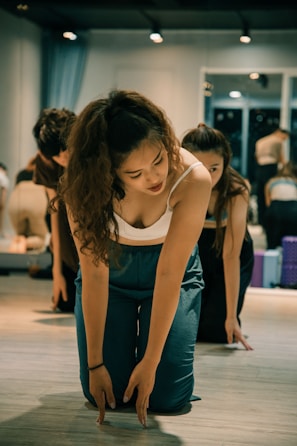 woman in blue tank top and blue denim jeans sitting on floor