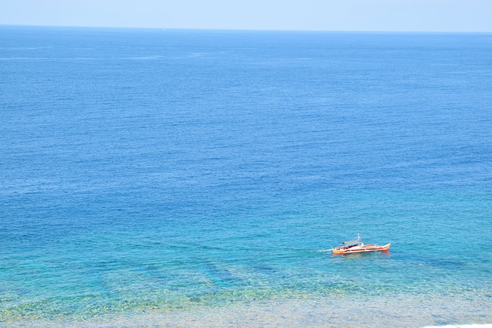 white and brown boat on blue sea during daytime