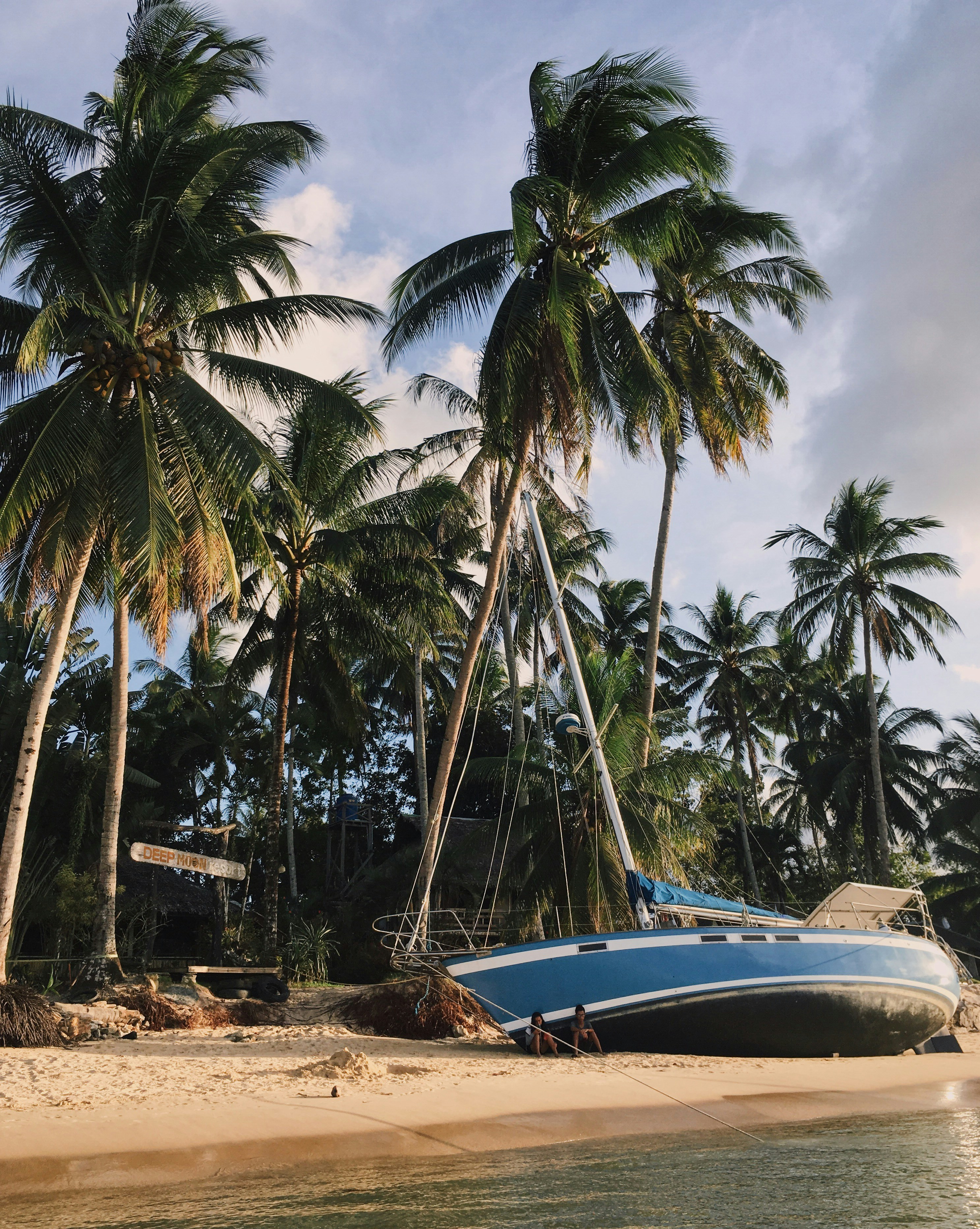 white and blue boat on beach shore during daytime
