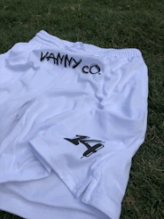 a white soccer uniform laying on the ground