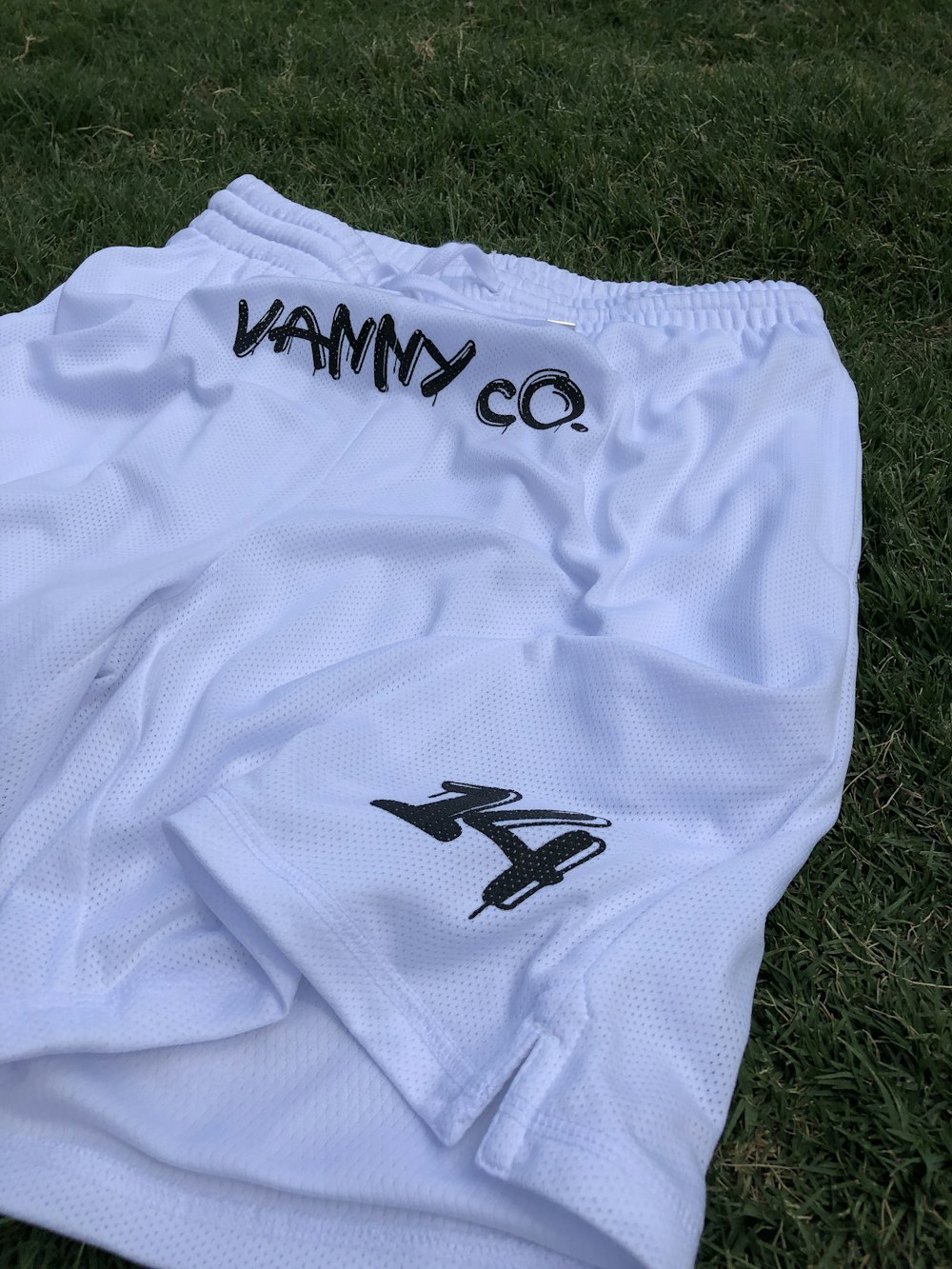 a white soccer uniform laying on the ground