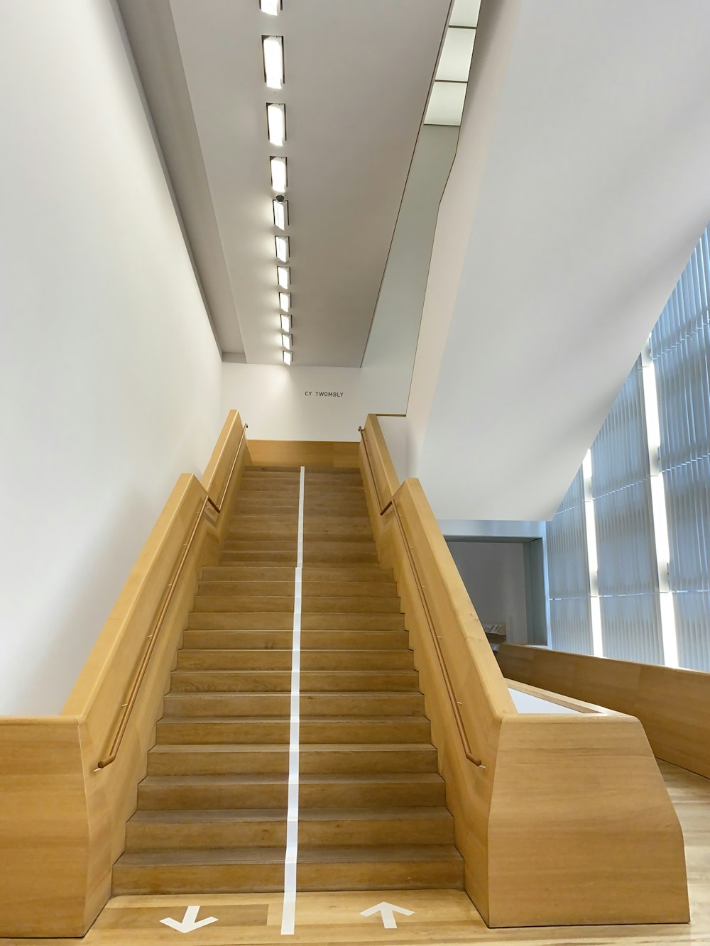 brown wooden staircase with white wall