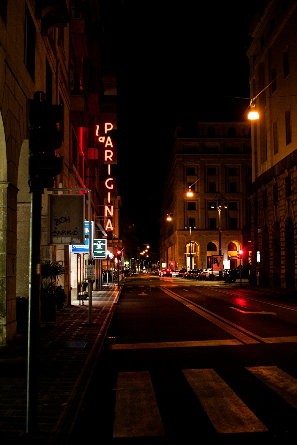 cars on road in between buildings during night time