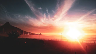 A vibrant sunset over Málaga's coastline with app interface overlay.