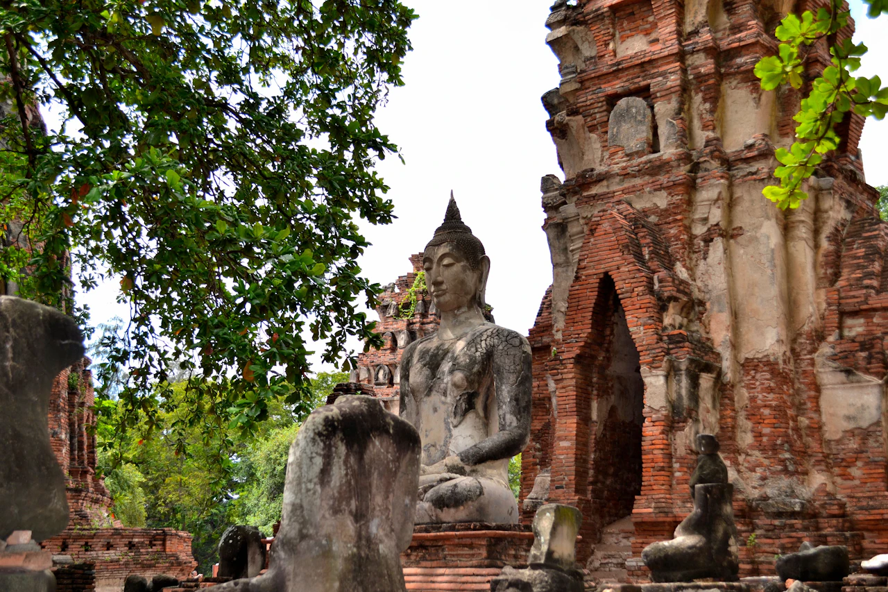 A large Buddha statue among the brick ruins of Ayutthaya Historical Park