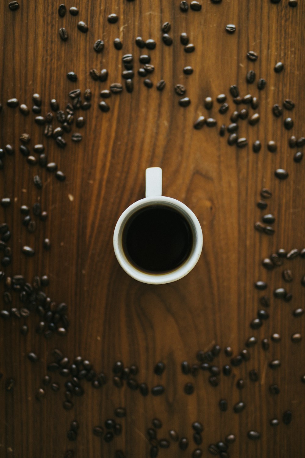 white ceramic mug on brown wooden table