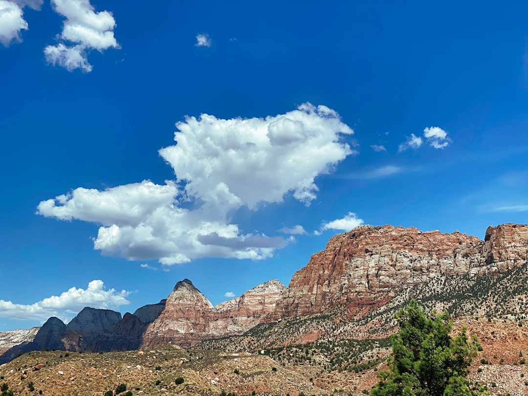 brown rocky mountain under blue sky and white clouds during daytime