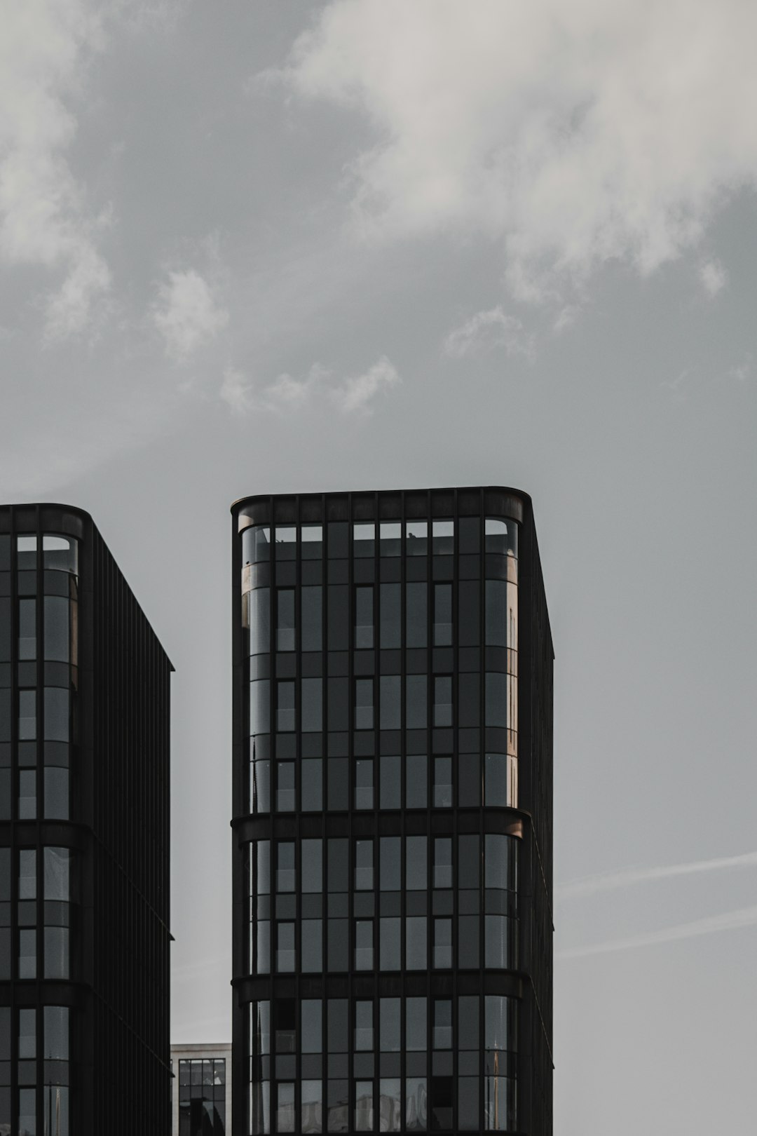 black and white building under white clouds during daytime