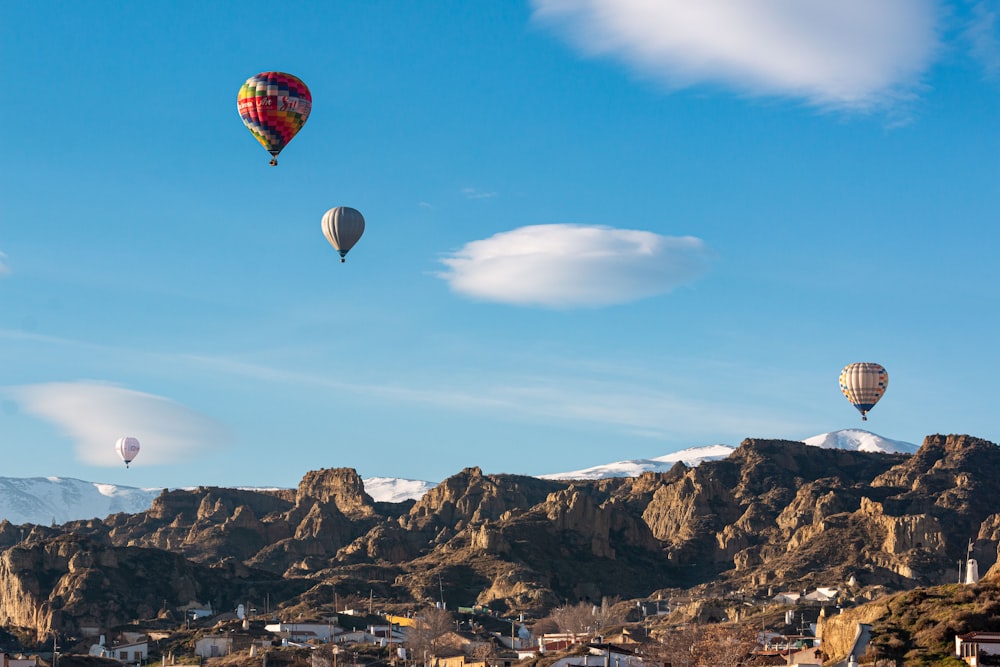 Roter und schwarzer Heißluftballon fliegt über Brown Mountain Range