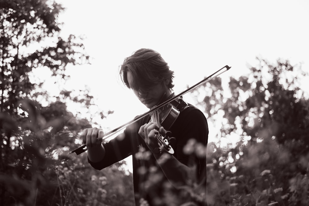 girl playing violin in grayscale photography