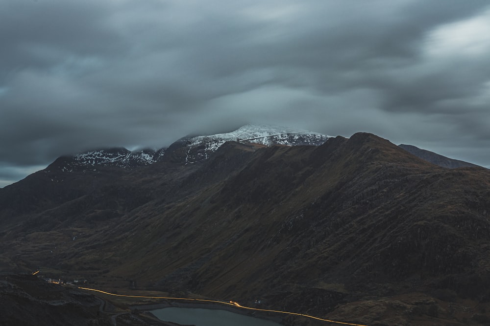 green and brown mountains under cloudy sky during daytime