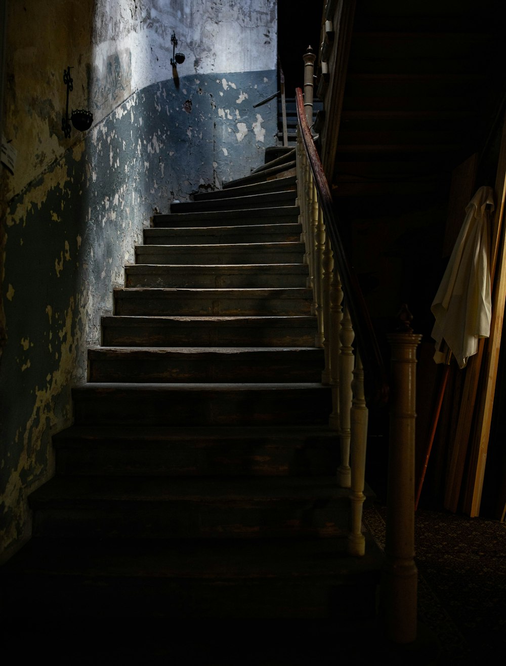 brown wooden staircase with blue wall