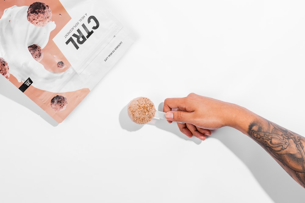 person holding two brown and white round cookies