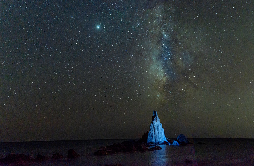 white and black rock formation under starry night